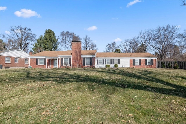 view of front of home featuring a front lawn, fence, brick siding, and a chimney