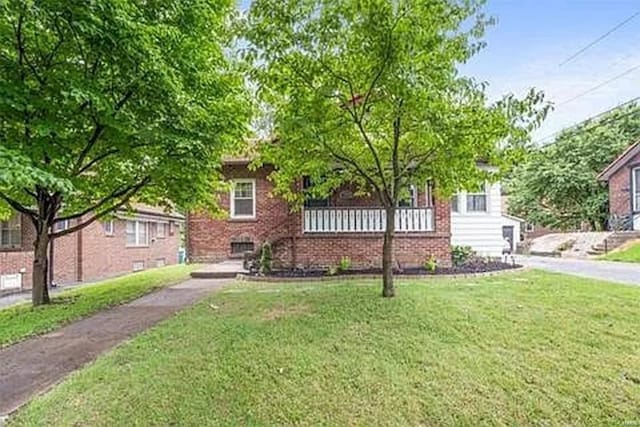 view of property hidden behind natural elements with a front lawn