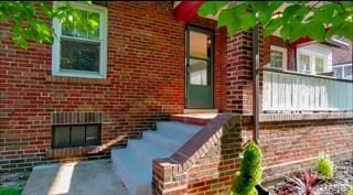 entrance to property featuring brick siding