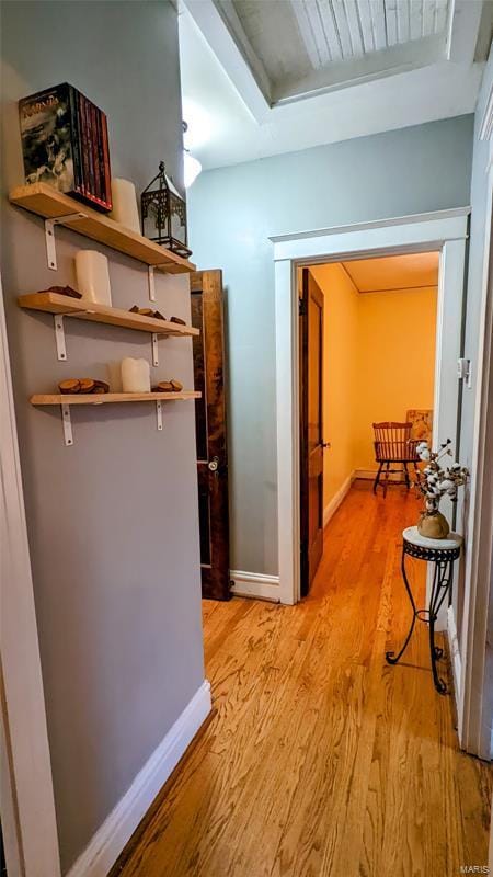 corridor with light wood-style flooring and baseboards