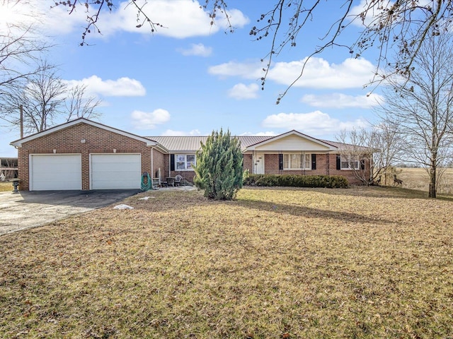 ranch-style home with a garage, a front yard, aphalt driveway, and brick siding