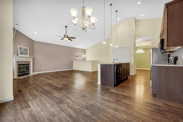 kitchen with hanging light fixtures, dark hardwood / wood-style flooring, black appliances, light stone counters, and ceiling fan with notable chandelier