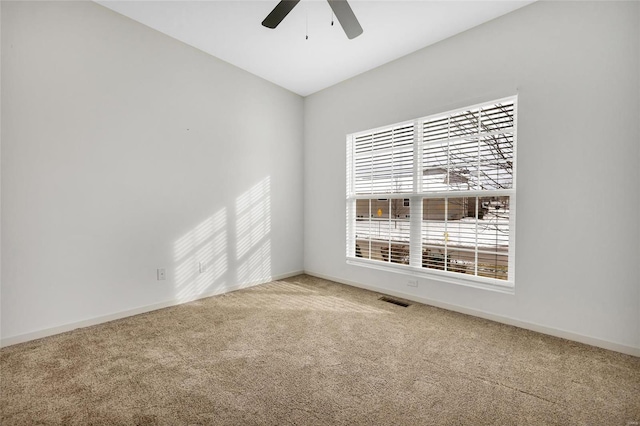 unfurnished room with ceiling fan and carpet