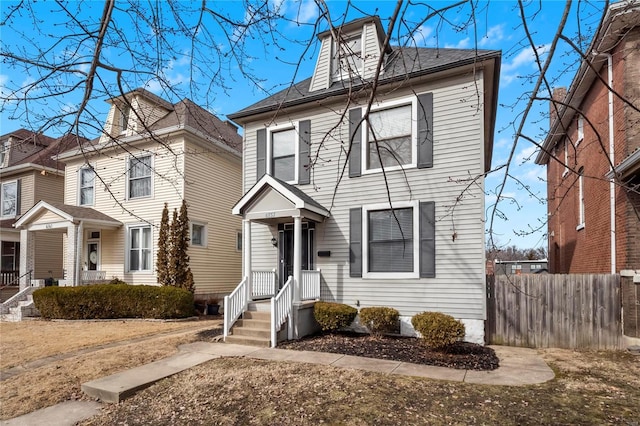 american foursquare style home featuring fence