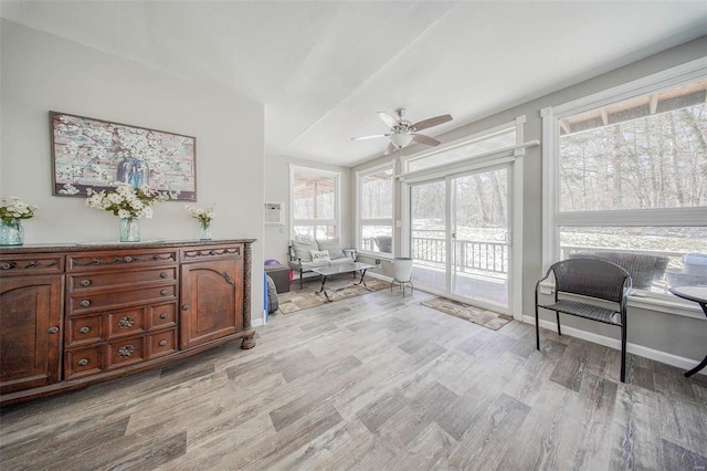 sitting room with a ceiling fan, light wood-type flooring, and baseboards