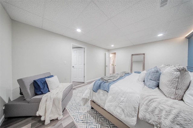 bedroom featuring wood finished floors, recessed lighting, and baseboards