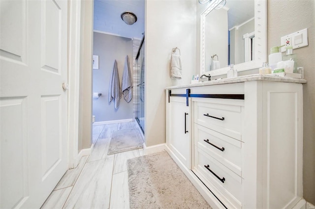 full bathroom featuring a shower stall, vanity, and baseboards