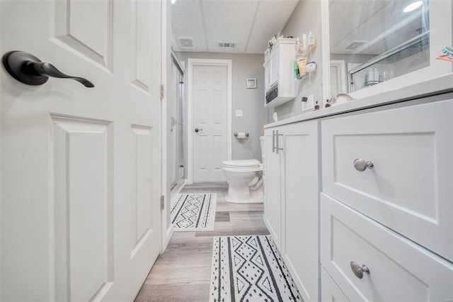 full bathroom with a shower stall, toilet, and wood finished floors