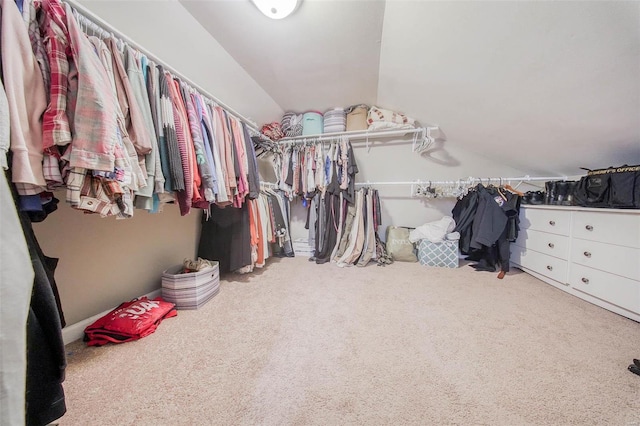 walk in closet with vaulted ceiling and carpet flooring