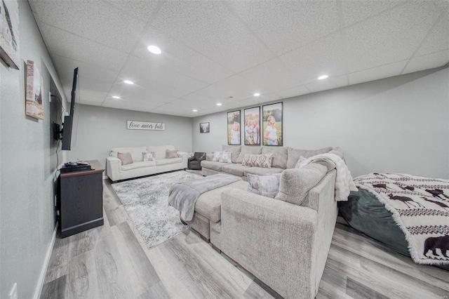 living area with wood finished floors, a paneled ceiling, and recessed lighting