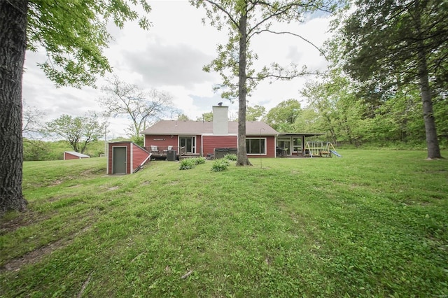 view of green lawn featuring an outdoor structure and a storage shed