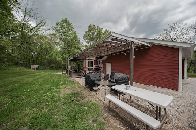 back of house featuring a lawn, a pergola, and a patio