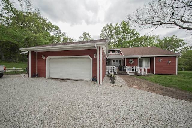 view of front of property featuring gravel driveway, a porch, and an attached garage
