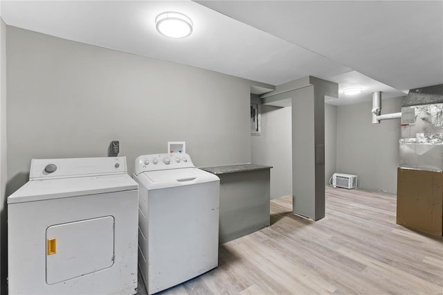 clothes washing area with light hardwood / wood-style floors and washing machine and clothes dryer