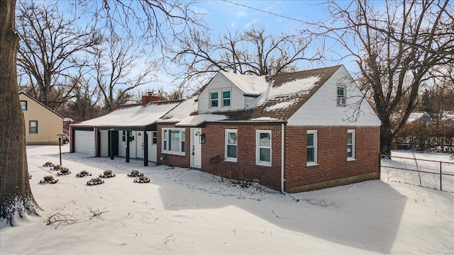 view of front of property featuring fence, a chimney, an attached garage, and brick siding