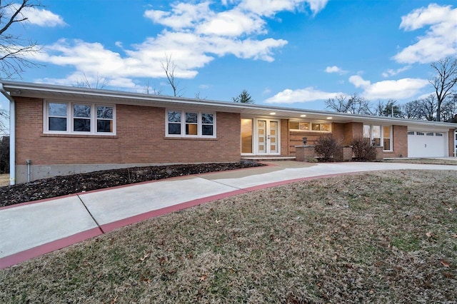 single story home featuring a garage, a front lawn, and french doors