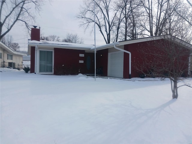 exterior space featuring a garage, a chimney, and cooling unit