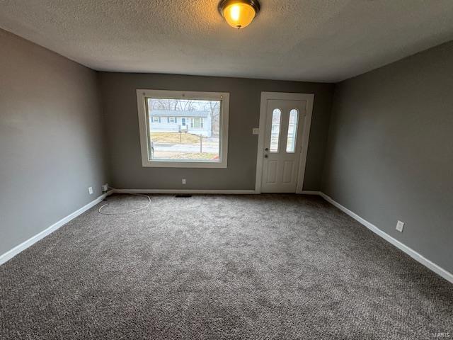 carpeted entrance foyer with a textured ceiling