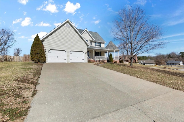 view of front of property with driveway, covered porch, fence, and a front lawn