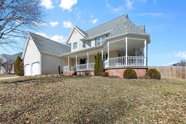 view of front of property featuring an attached garage, covered porch, fence, and a front yard