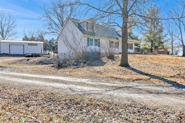 view of front of property featuring an outdoor structure and dirt driveway