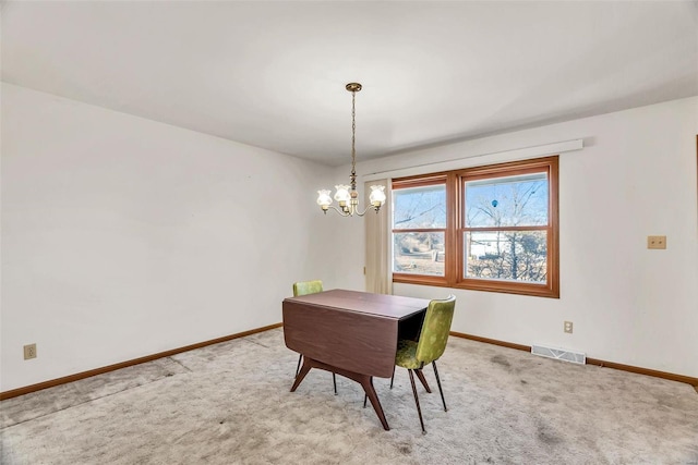 carpeted dining room featuring baseboards, visible vents, and an inviting chandelier