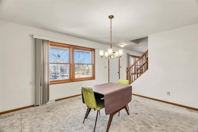 carpeted dining space featuring stairway, an inviting chandelier, and baseboards