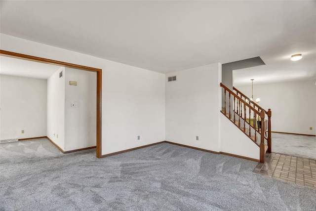 unfurnished room featuring carpet flooring, visible vents, baseboards, and stairs