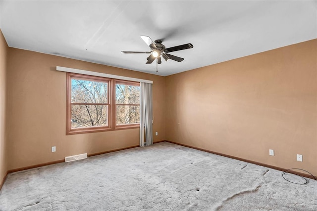 empty room with baseboards, visible vents, ceiling fan, and carpet flooring