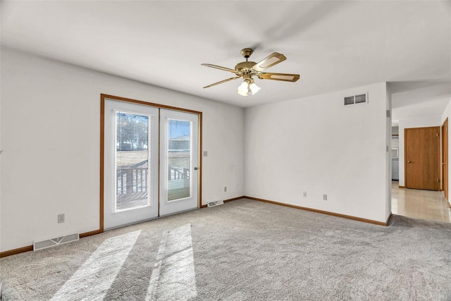 empty room featuring light carpet, visible vents, and a ceiling fan