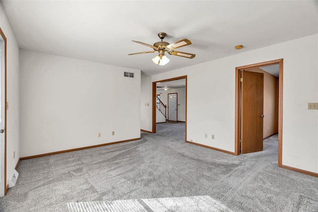 unfurnished room with light carpet, stairway, baseboards, and visible vents