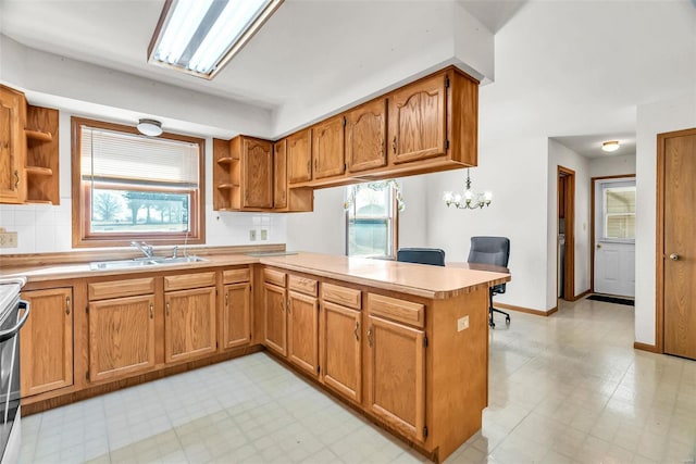 kitchen with a peninsula, open shelves, a sink, light countertops, and light floors