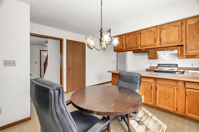 dining area featuring a chandelier, baseboards, and light floors