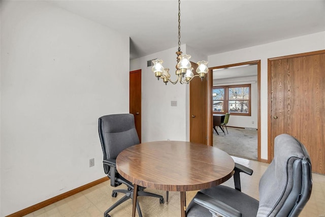 dining room featuring light floors, baseboards, and a chandelier