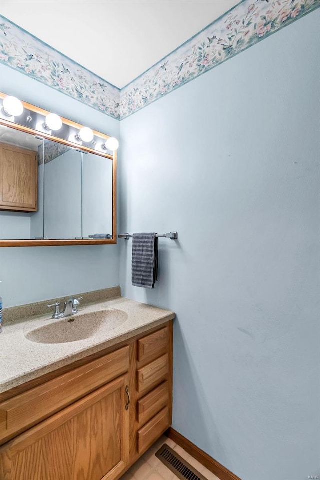 bathroom featuring visible vents, vanity, and baseboards