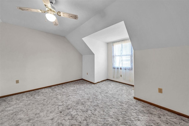 additional living space with light carpet, lofted ceiling, a ceiling fan, and baseboards