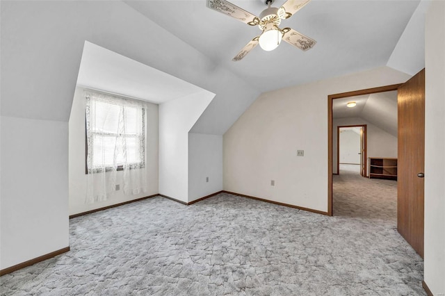 additional living space featuring baseboards, vaulted ceiling, and light colored carpet