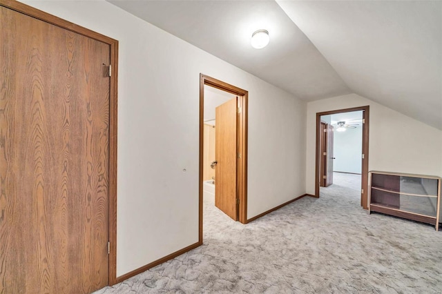 additional living space with lofted ceiling, baseboards, and light colored carpet