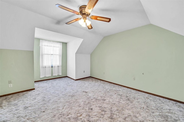 additional living space featuring lofted ceiling, light carpet, a ceiling fan, and baseboards