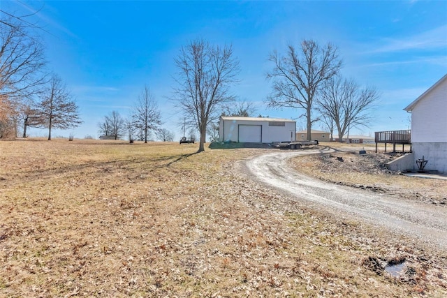 view of street with gravel driveway and a rural view