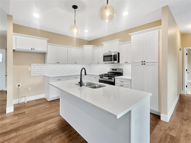 kitchen with white cabinetry, appliances with stainless steel finishes, sink, and hanging light fixtures