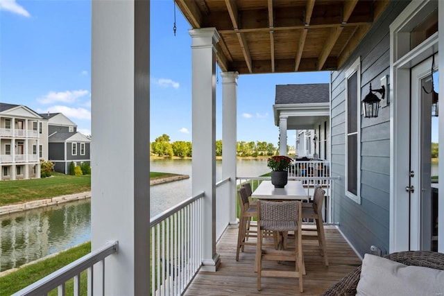 balcony featuring a water view and outdoor dining area