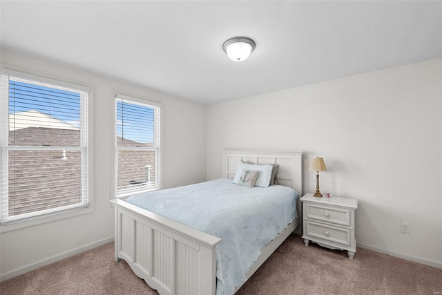 bedroom with baseboards and light colored carpet