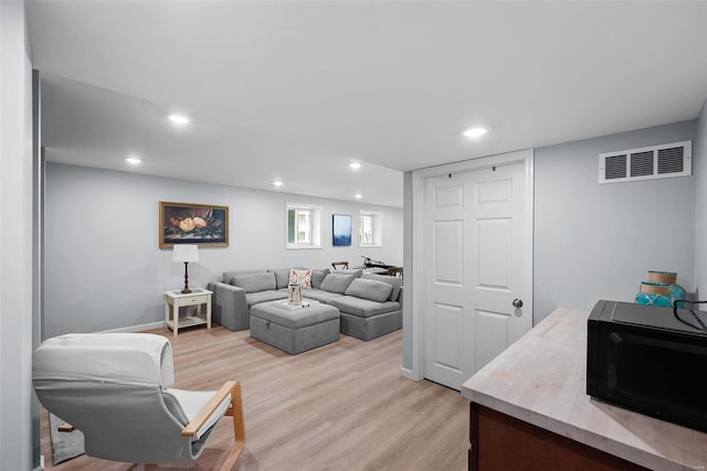 living area featuring light wood finished floors, visible vents, and recessed lighting