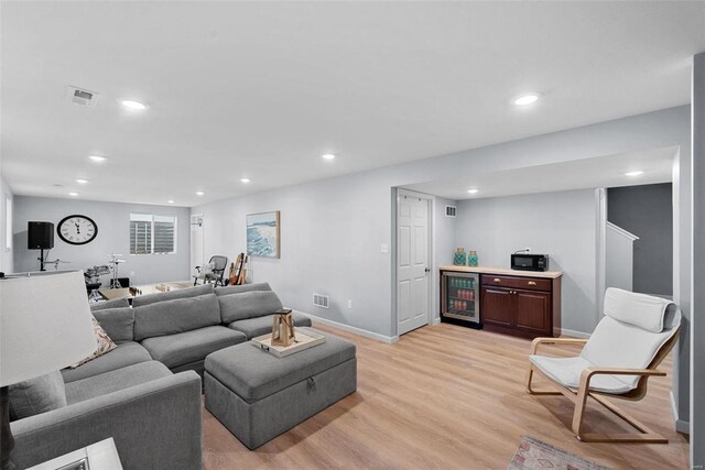 living area featuring visible vents, recessed lighting, beverage cooler, and light wood-type flooring