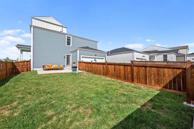 rear view of property featuring board and batten siding, a fenced backyard, a yard, and a patio