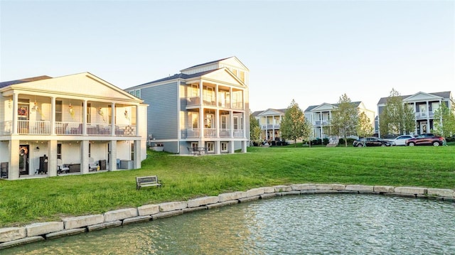 rear view of property with a lawn and a water view