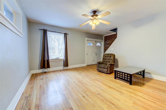 unfurnished room with a ceiling fan, light wood-style flooring, and baseboards