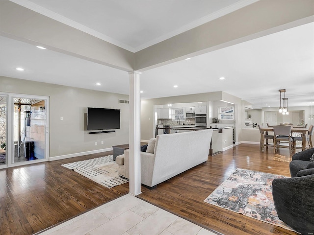 living room with crown molding, recessed lighting, wood finished floors, and baseboards