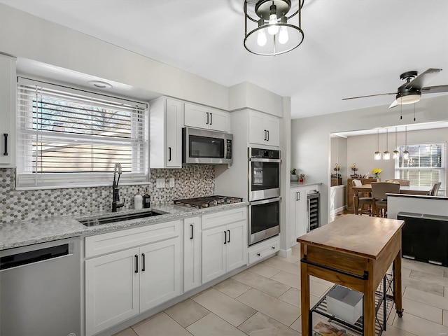 kitchen with decorative backsplash, plenty of natural light, appliances with stainless steel finishes, and a sink